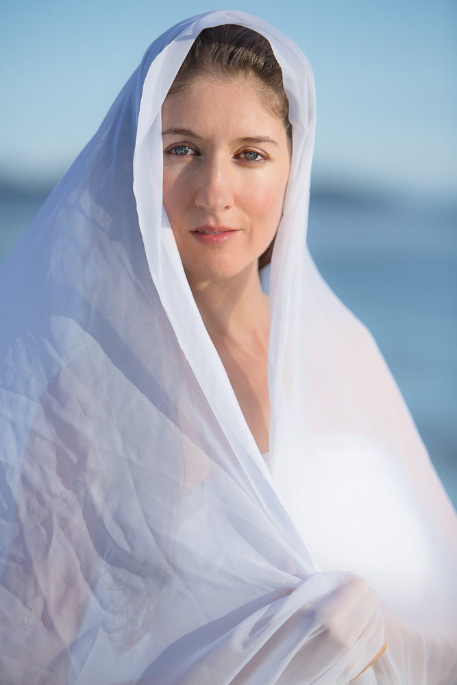 Laura Hollick, wrapped in a white veil, looking toward the camera